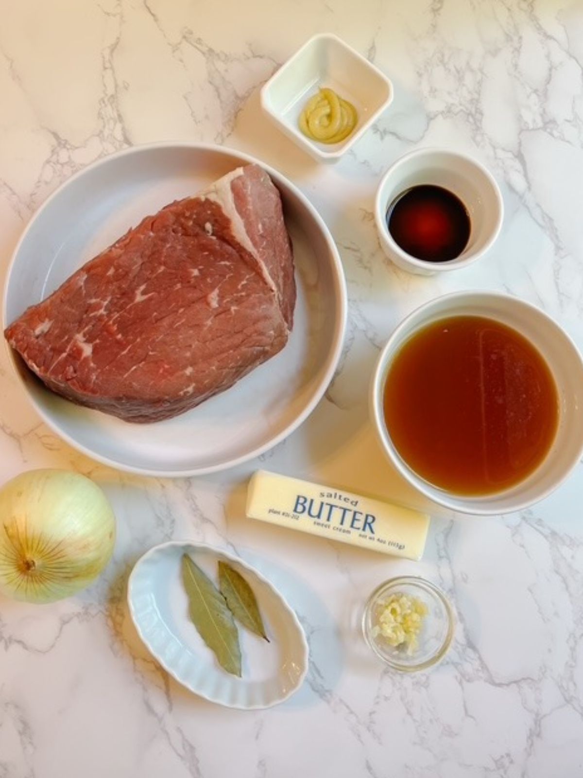 roast, butter, garlic, mustard, bone broth, onion, bay leaves, and sauce