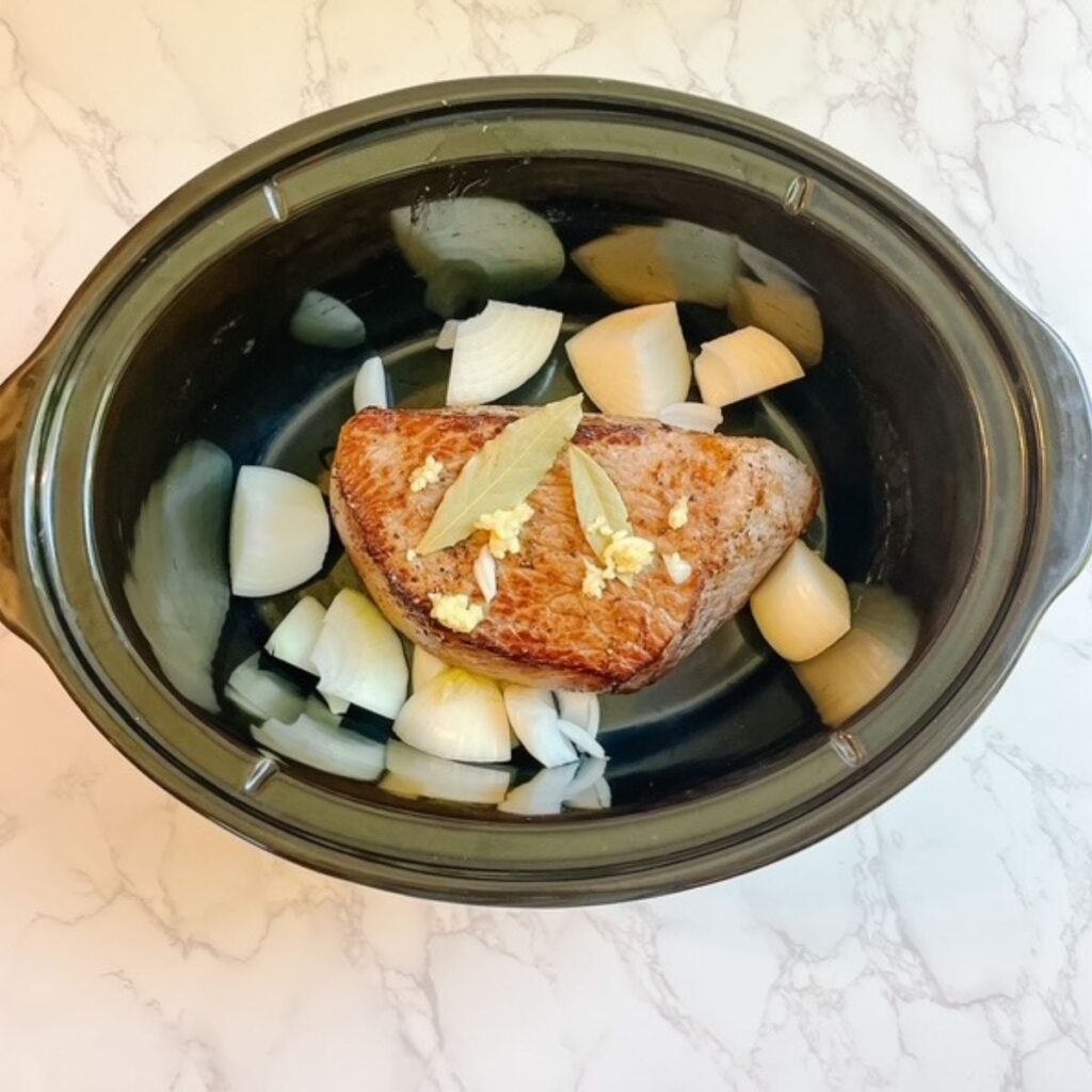 Add chopped onion, garlic, and bay leaves