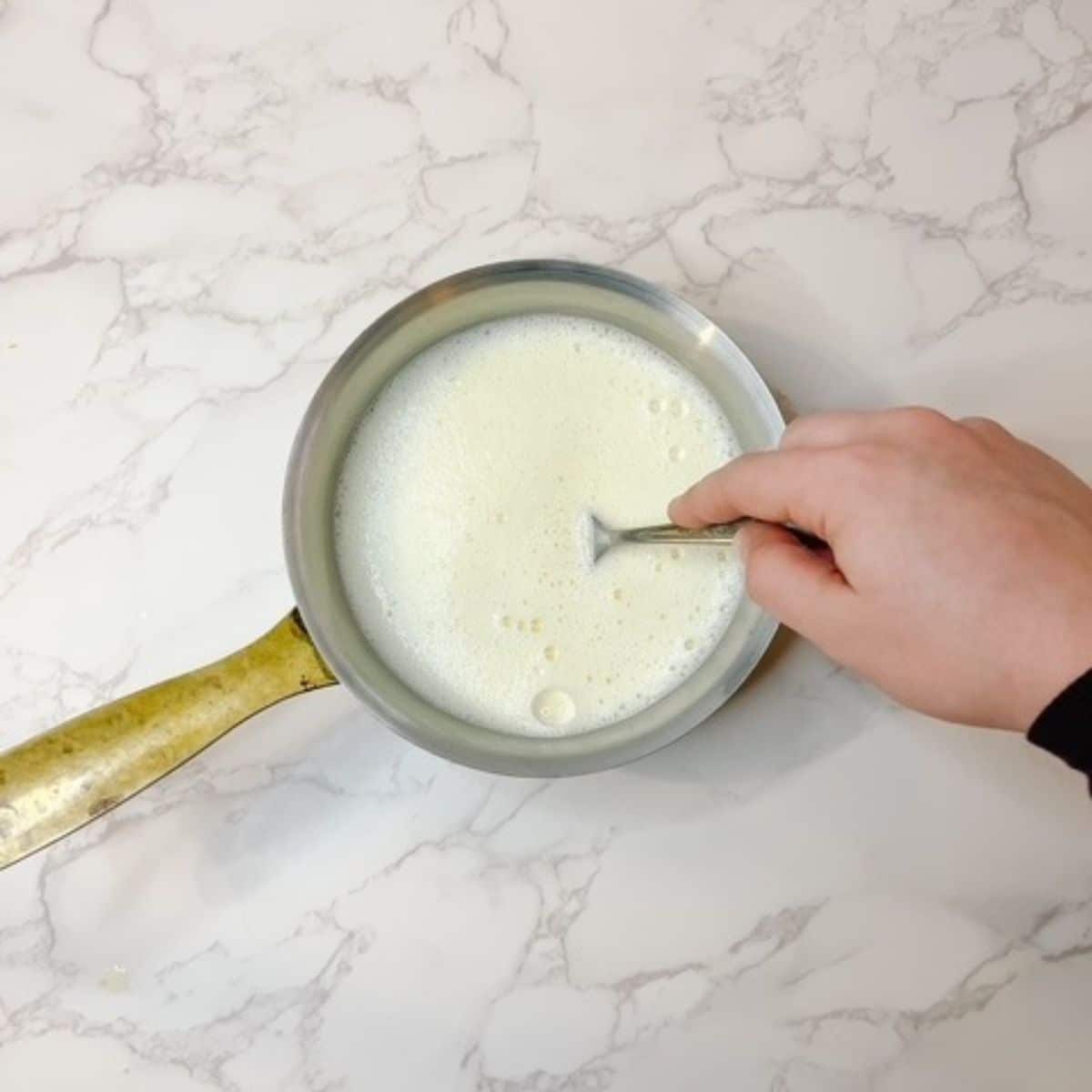 temper the egg yolks with the hot milk