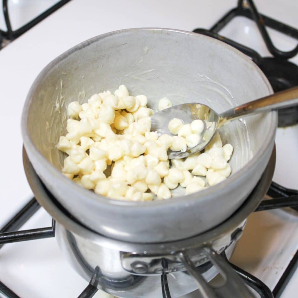 Melt white chocolate chips in a double broiler on the stove.
