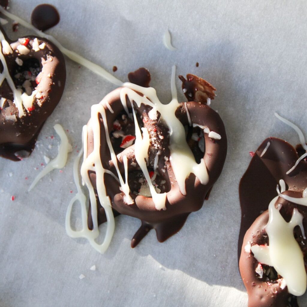 Drizzle white chocolate over chocolate dipped pretzels.