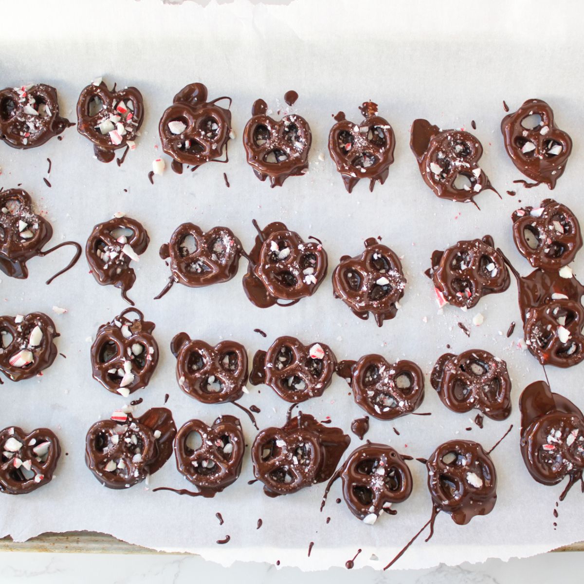 Lay chocolate dipped pretzels on a cookie sheet with parchment paper and sprinkle with peppermint.