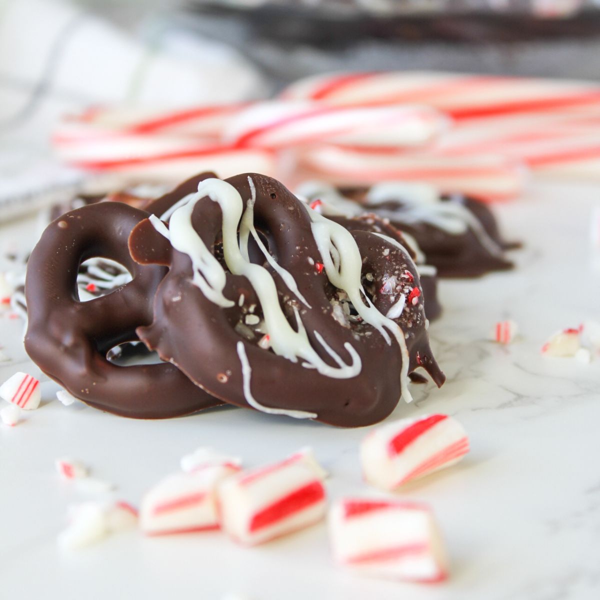 Chocolate dipped pretzels with white chocolate and peppermint drizzle are a delicious treat.