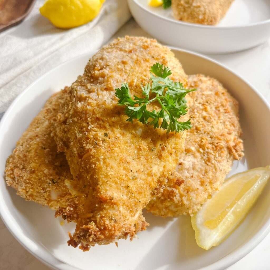 Sourdough fried chicken with fresh parsley sprig.