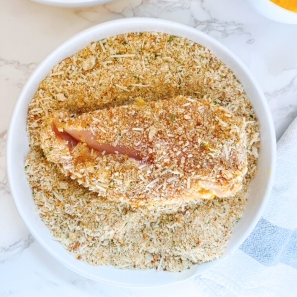 Dredge the chicken breast in the sourdough breadcrumb mixture.
