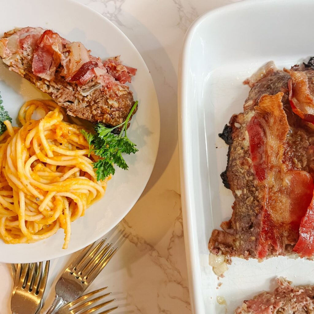 A juicy meatloaf with a plate of butternut squash pasta.