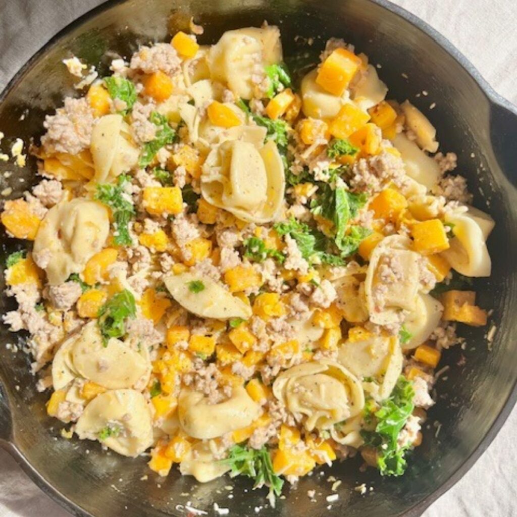 A skillet of butternut squash tortellini.