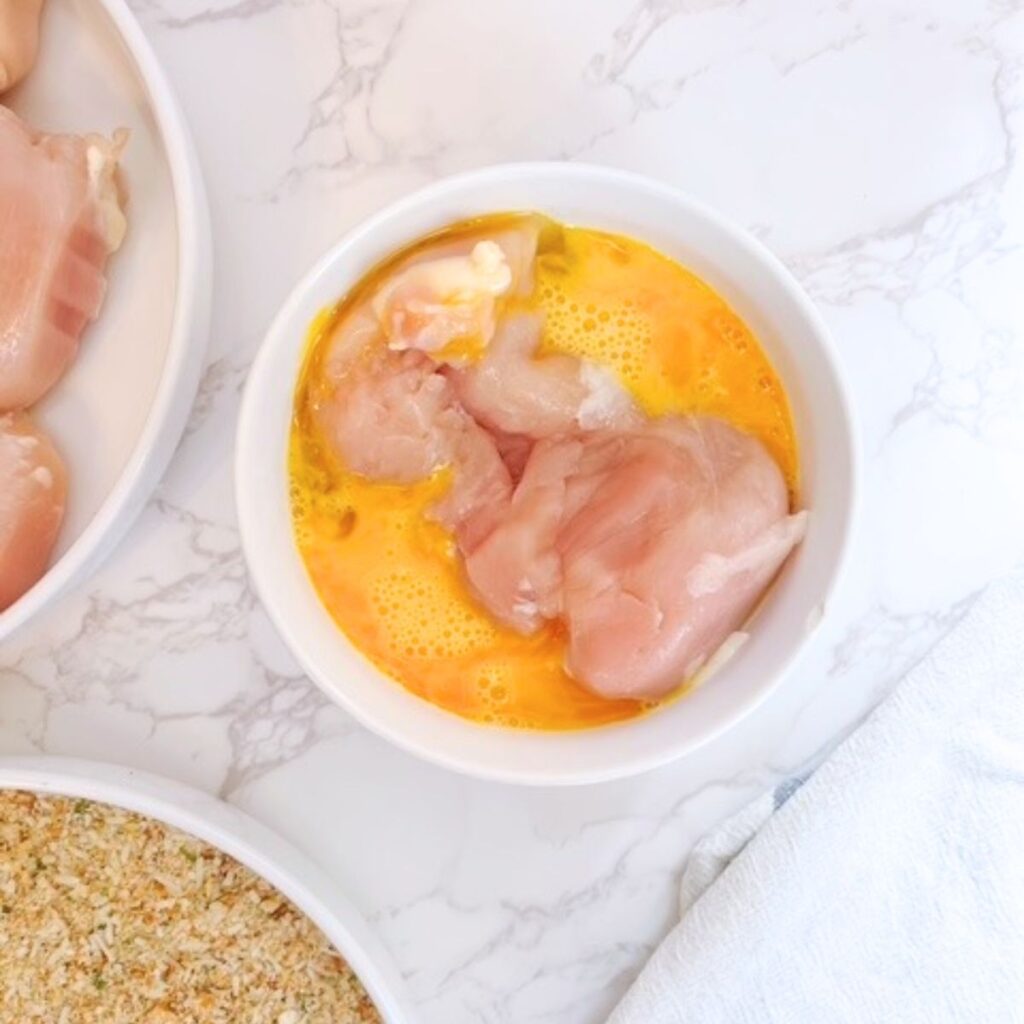 Dredge each chicken breast in the whisked egg mixture.