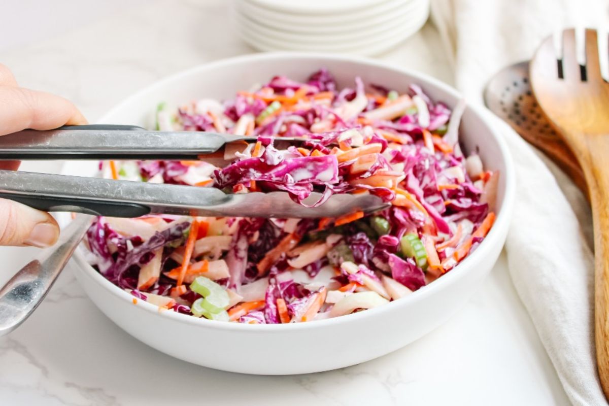 red cabbage salad being grabbed with tongs