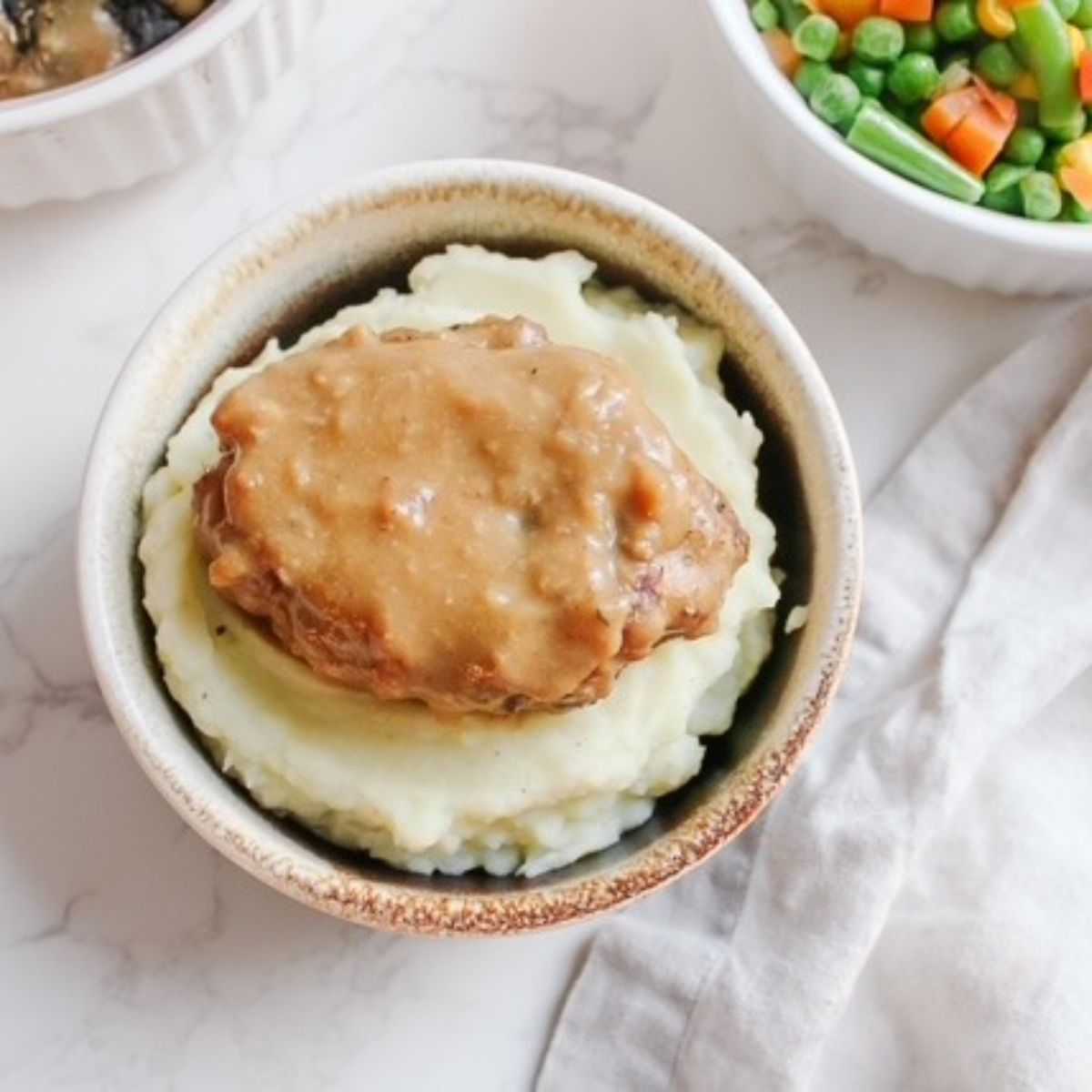 Salisbury steak on top of mashed potatoes