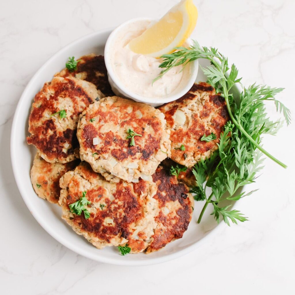 Garnish the salmon patties with fresh parsley and serve with homemade salmon sauce!