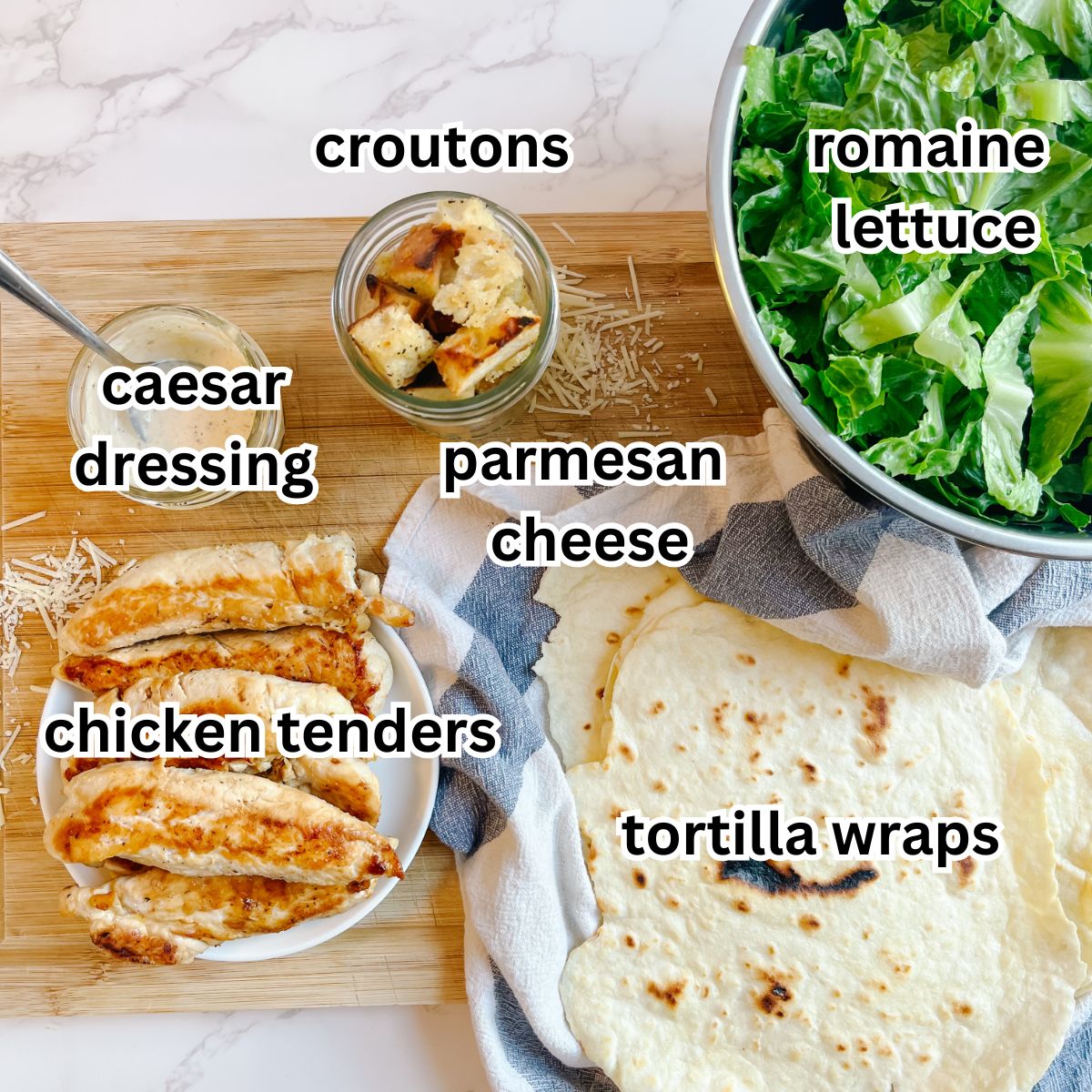 The main ingredients for a chicken caesar wrap-croutons, romaine lettuce, parmesan cheese, caesar dressing, chicken tenders, and tortilla wraps.