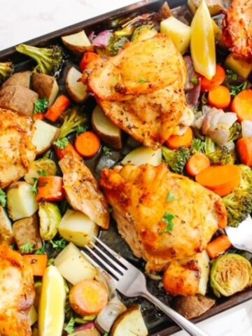 baked chicken and veggies with forks