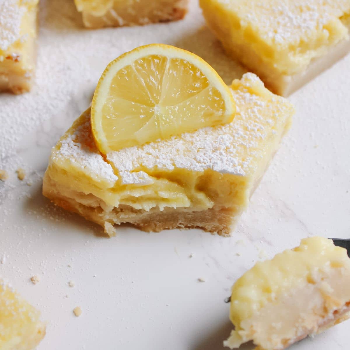 Dust lemon cream cheese bars with powdered sugar and serve with a fresh lemon slice!