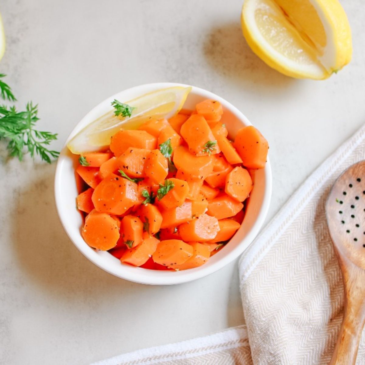 steamed carrots with parsley and lemon wedge