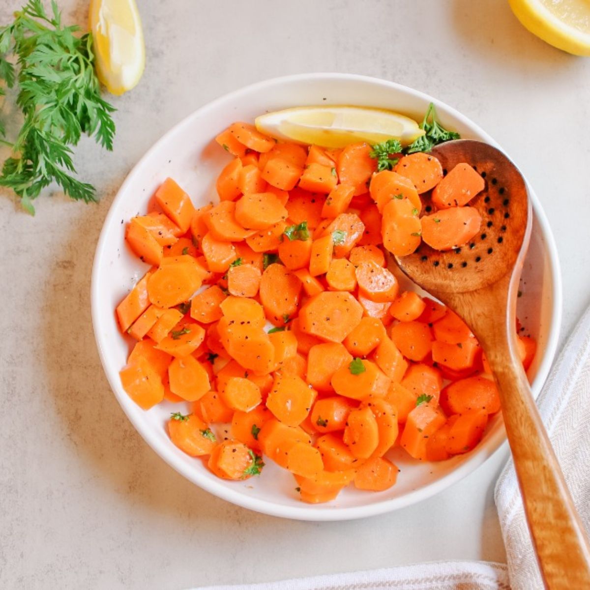 steamed carrots with wooden serving spoon