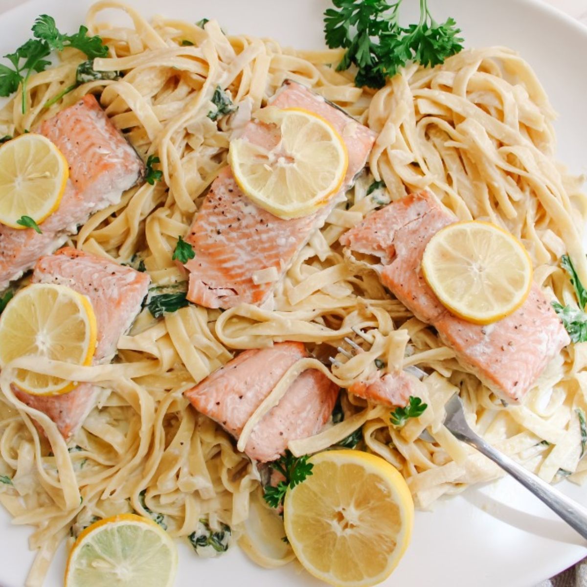 lemon salmon pasta with fork on platter
