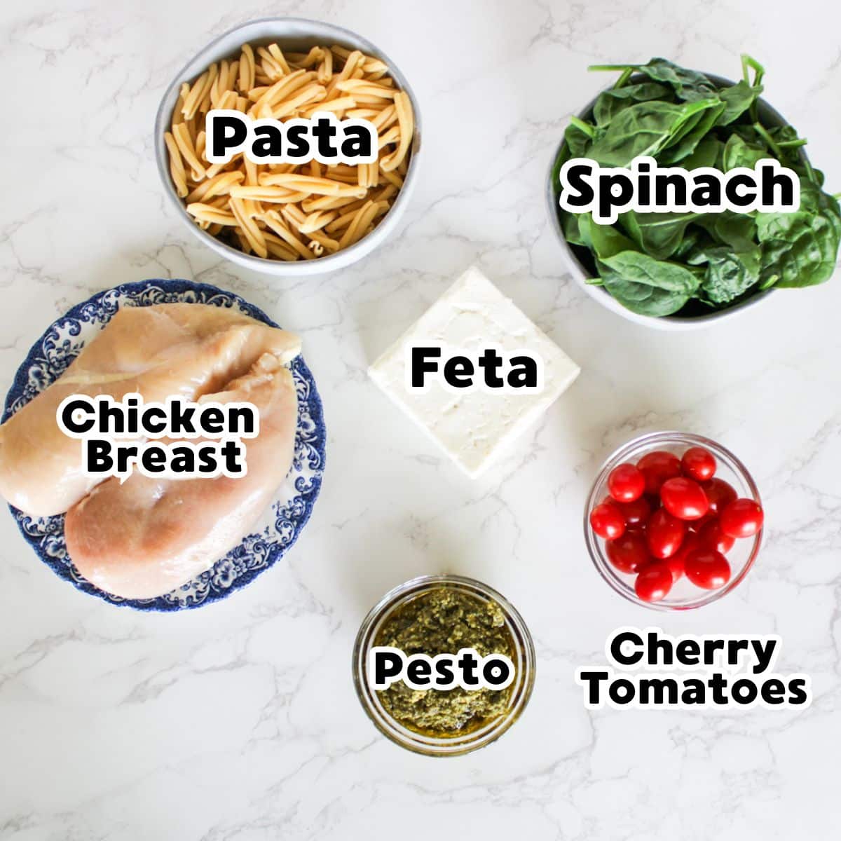The ingredients you need for chicken feta pasta-pasta, spinach, feta, cherry tomatoes, pesto, chicken breast.