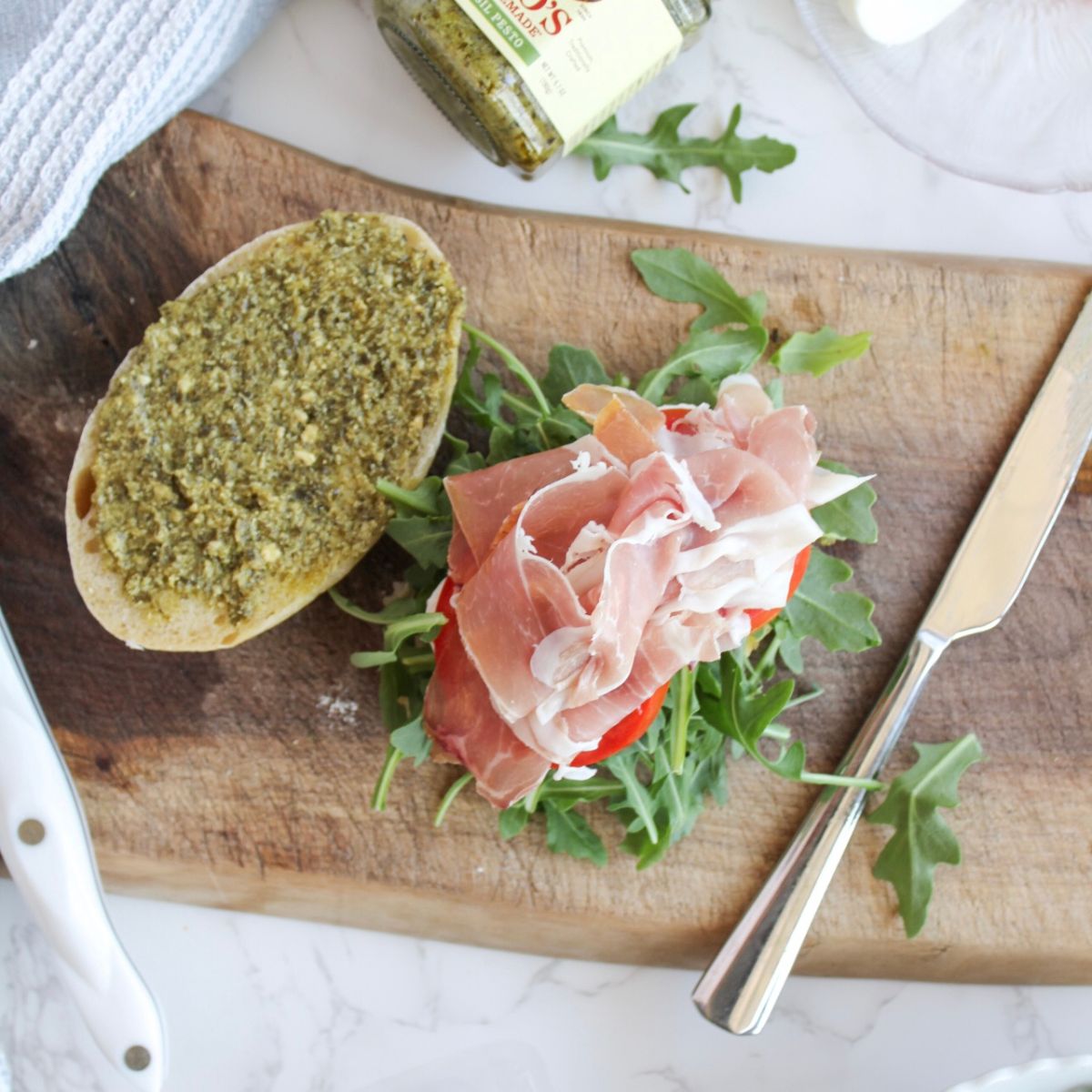 Add prosciutto to the pesto panini.