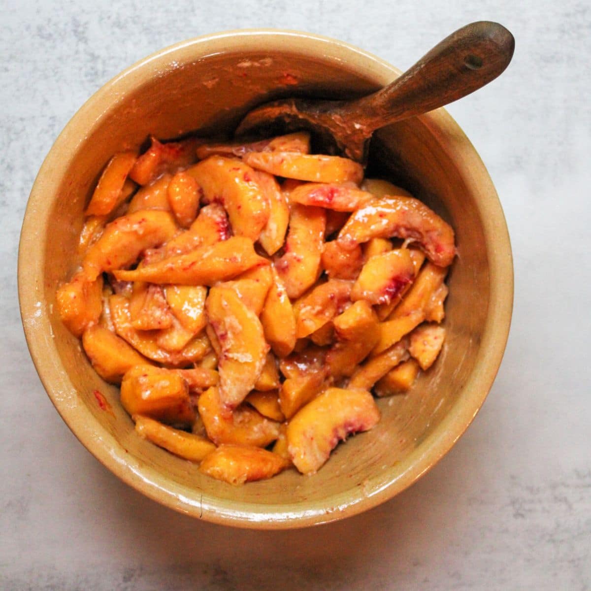 Stir all of the peach crisp ingredients together in a large mixing bowl until the peach juices have dissolved the flour.