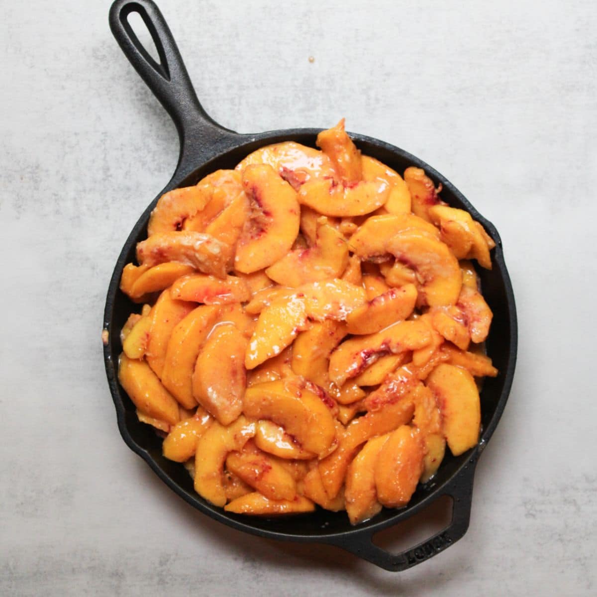 Peach crisp filling in a cast iron skillet.