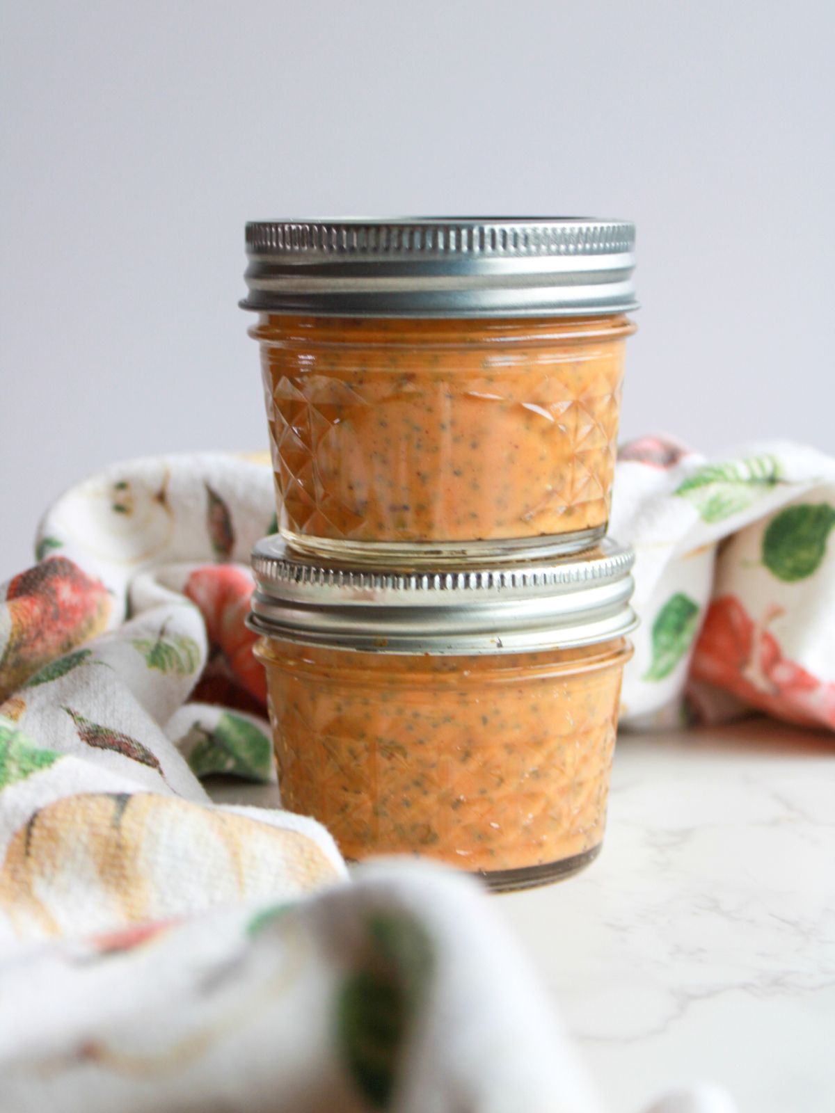 2 small mason jars with chia pudding stacked on top of one another.