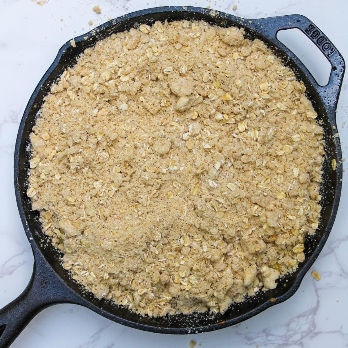 Cover the apple crisp filling with the oat crumble topping.