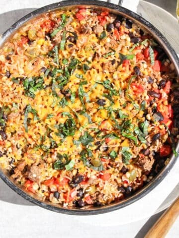 A stainless steel skillet filled with a ground beef taco meal.