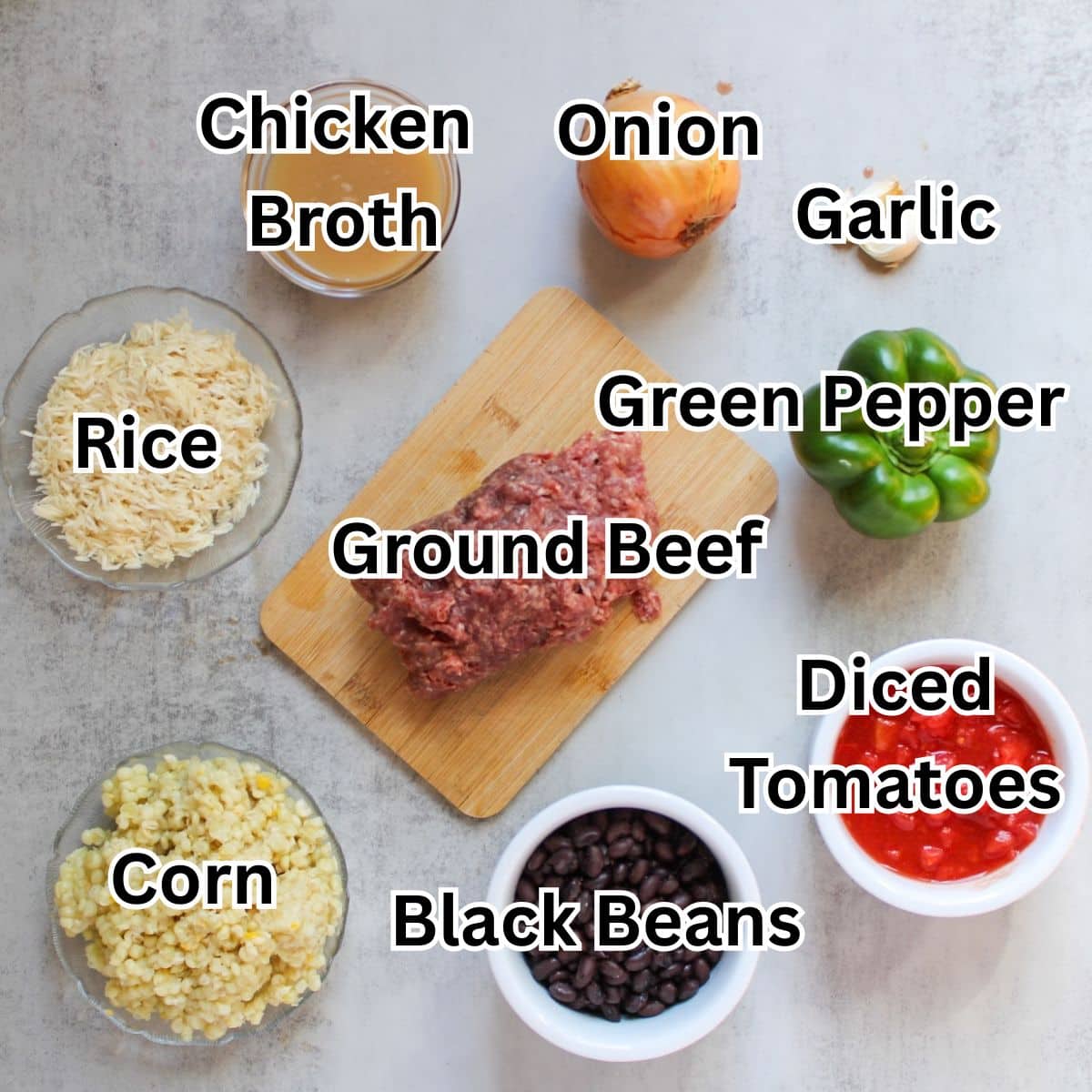 Ground beef taco skillet ingredients-ground beef, broth, onion, garlic, pepper, diced tomatoes, beans, corn and rice.