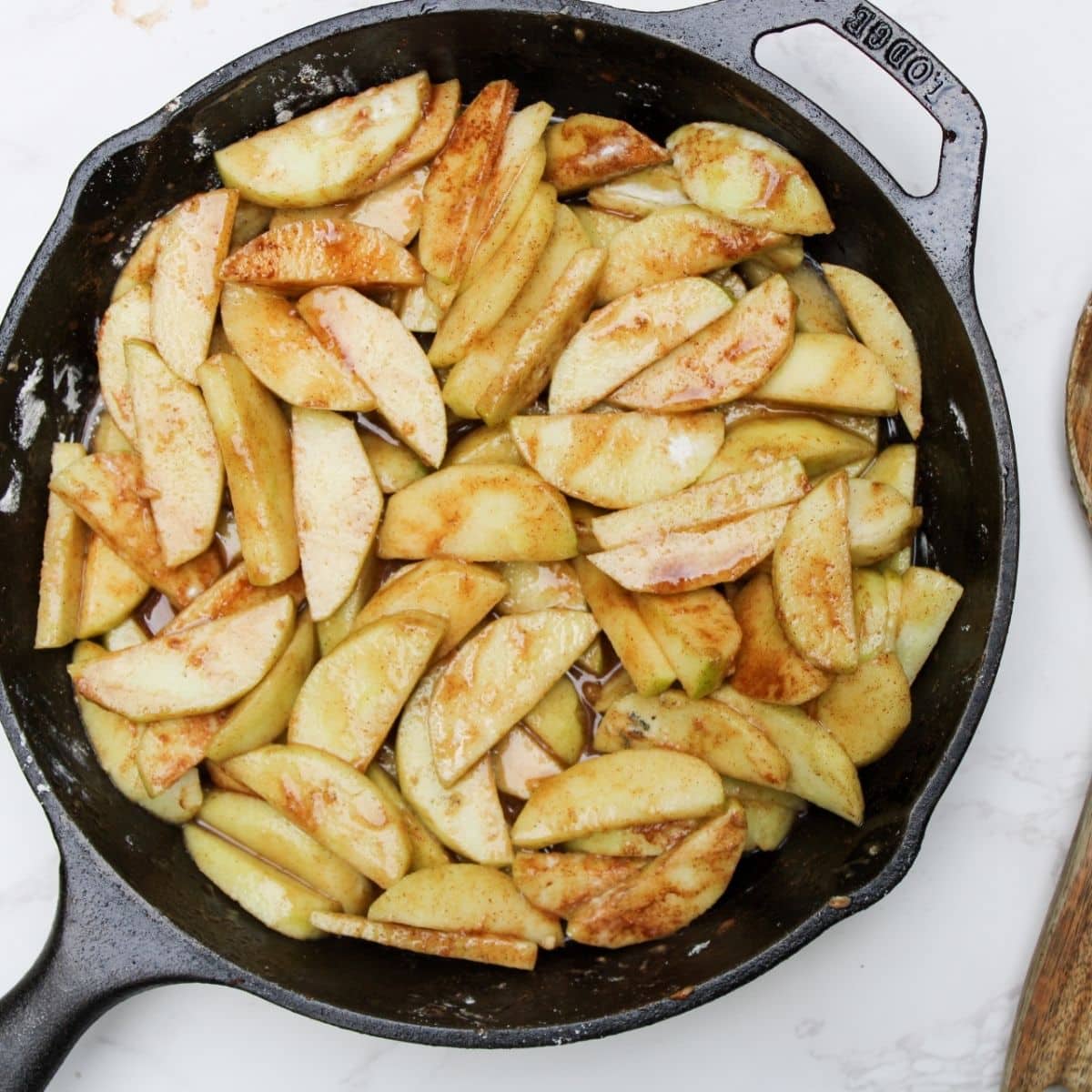 A cast iron skillet with apple crisp filling.