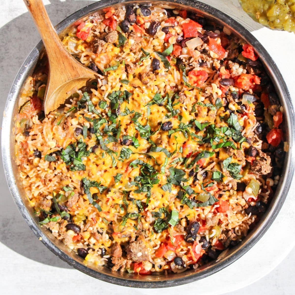A ground beef taco skillet with a wooden spoon.